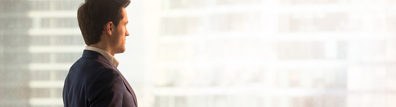 Man looking out a brightly lit window