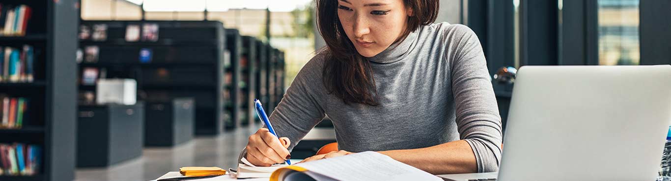 Woman in a library working at a table