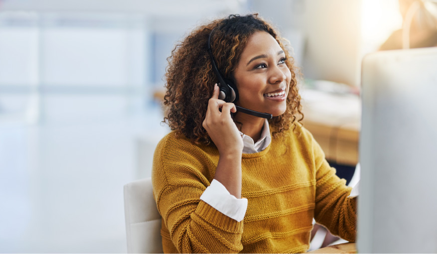 Woman on the computer using a headset to speak