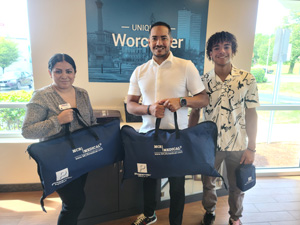 Three people holding donated items