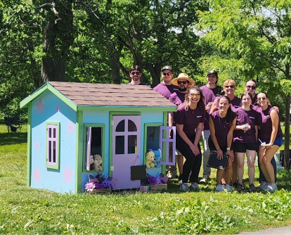 UniBank explore group with the playhouse they built for the children of a veteran