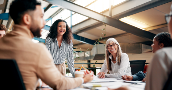 Business team at a table smiling at each other