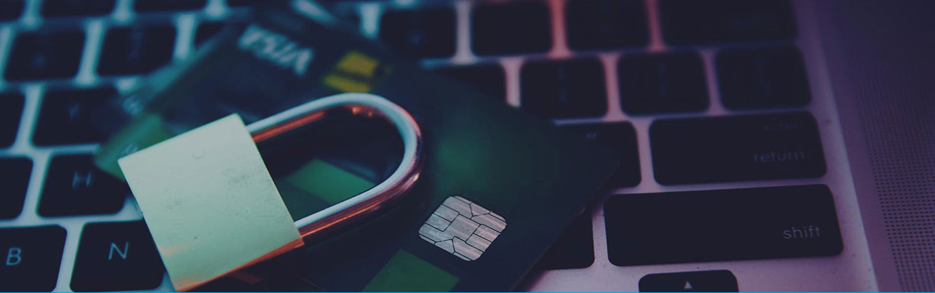 Padlock resting atop a laptop and credit card