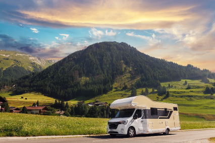 RV driving in front of a mountain