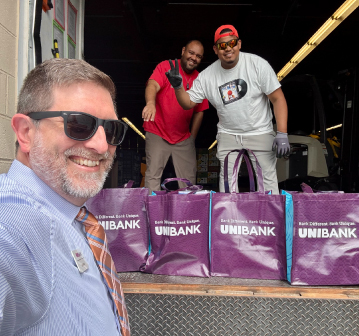 Eric Ward posing with two men and donation bags