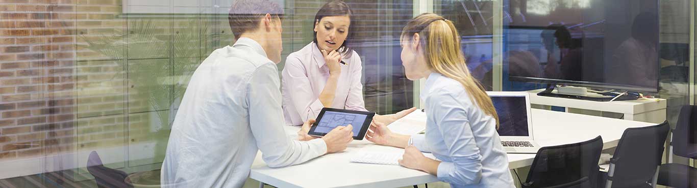 Three people in a conference room working together